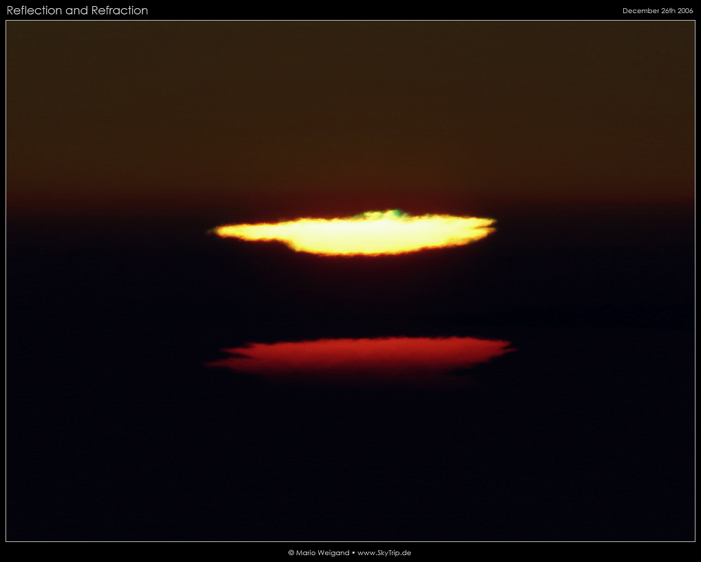 Grner Blitz und verzerrte Sonnenscheibe bei Sonnenuntergang