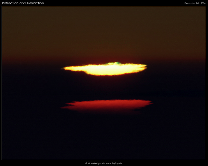 Grner Blitz und verzerrte Sonnenscheibe bei Sonnenuntergang