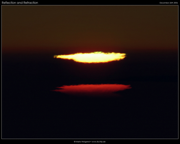 Grner Blitz und verzerrte Sonnenscheibe bei Sonnenuntergang