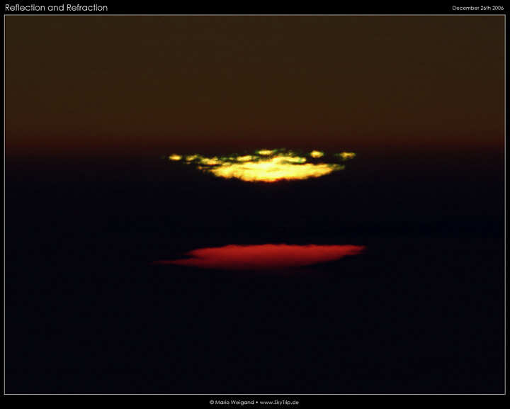 Grner Blitz und verzerrte Sonnenscheibe bei Sonnenuntergang