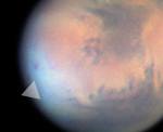 Ascraeus Mons (rechts) und Pavonis Mons (links) überragen morgentlichen Nebel